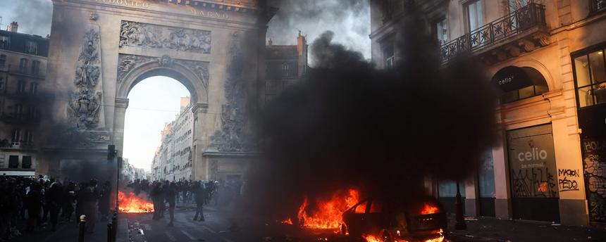 Demonstranten neben einem brennenden Auto in der Nähe der Porte Saint-Denis während einer Kundgebung gegen die „hohen Lebenshaltungskosten“ in Paris am 17. Oktober 2026 – im Rahmen eines landesweiten Mobilisierungsaufrufs, der verschiedene Gruppen vereint, die ihrem Unmut Ausdruck verleihen: ehemalige „Gelbwesten“, Schüler und Studierende, Klimaaktivisten sowie Landwirte.