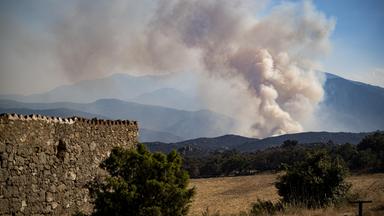 Rauch steigt auf, während am 6. Juli 2026 ein großer Waldbrand in den östlichen französischen Pyrenäen bei Vinca außer Kontrolle gerät.