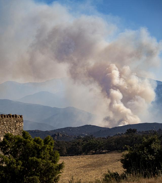 Rauch steigt auf, während am 6. Juli 2026 ein großer Waldbrand in den östlichen französischen Pyrenäen bei Vinca außer Kontrolle gerät.