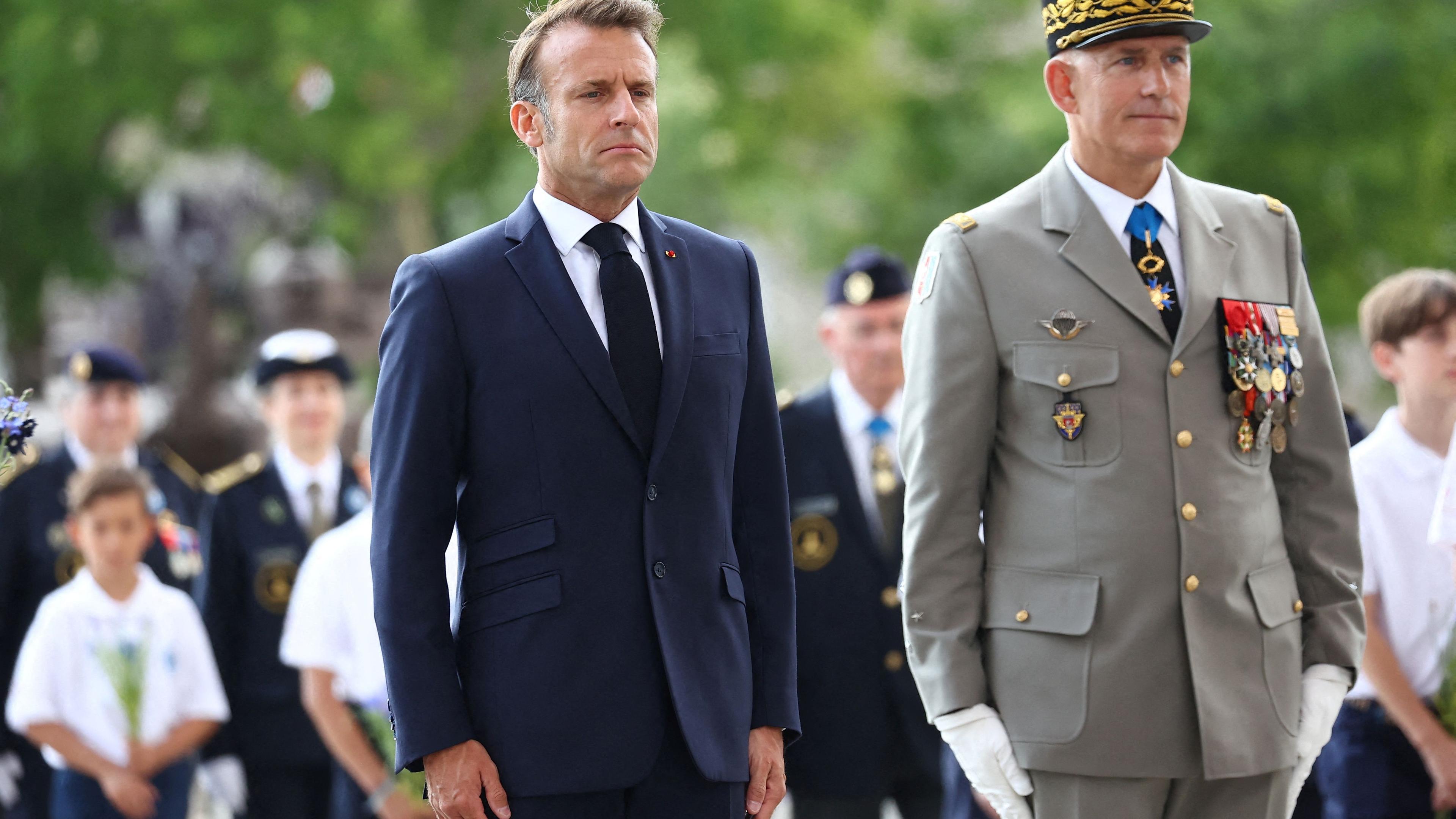 Der französische Präsident Emmanuel Macron und der Militärgouverneur von Paris, Loïc Mizon, nehmen an einer Zeremonie zur Feier des 100. Jahrestages der Vereinigung am Arc de Triomphe teil.