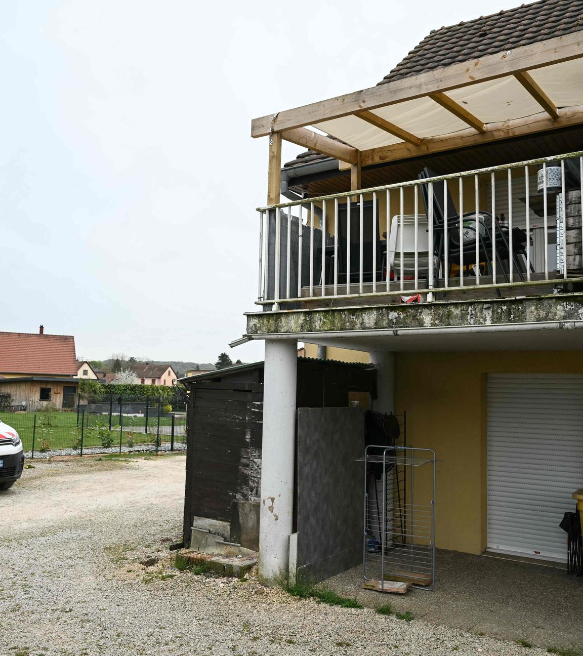 Das Foto zeigt ein Wohngebäude mit der Terrasse der beteiligten Verdächtigen im ersten Stock (R) und den Parkplatz an der Stelle, wo am 10. April 2026 ein Junge nackt und unterernährt auf einem Müllhaufen in einem Lieferwagen entdeckt wurde, in dem er eingesperrt gehalten worden war. Das Foto entstand in Hagenbach in Ostfrankreich.