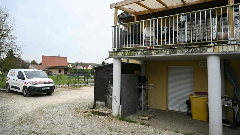 Das Foto zeigt ein Wohngebäude mit der Terrasse der beteiligten Verdächtigen im ersten Stock (R) und den Parkplatz an der Stelle, wo am 10. April 2026 ein Junge nackt und unterernährt auf einem Müllhaufen in einem Lieferwagen entdeckt wurde, in dem er eingesperrt gehalten worden war. Das Foto entstand in Hagenbach in Ostfrankreich.