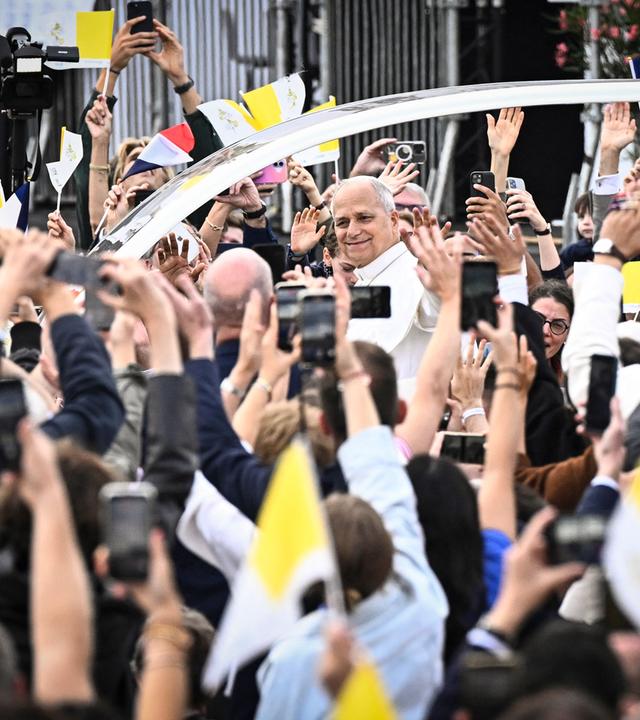 Papst Leo XIV. winkt der Menge aus dem Papamobil zu, während er die Champs-Élysées entlangfährt, um auf der Place de la Concorde im Zentrum von Paris eine feierliche Messe unter freiem Himmel zu zelebrieren.