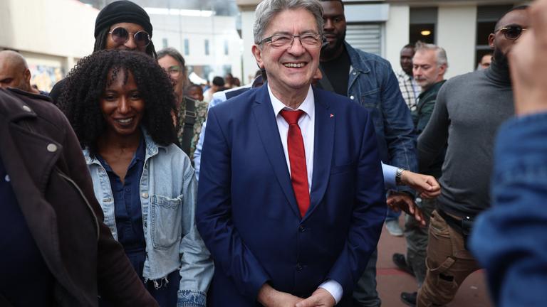 Founder of left-wing party La France Insoumise (LFI) Jean-Luc Melenchon (C) walks during an encounter with locals to support Nouveau Front Populaire (NFP), a left-wing coalition for the legislatives elections, candidate Adel Amara (not pictured) as part of a political campaign visit in Villiers-sur-Marne on July 5, 2024.