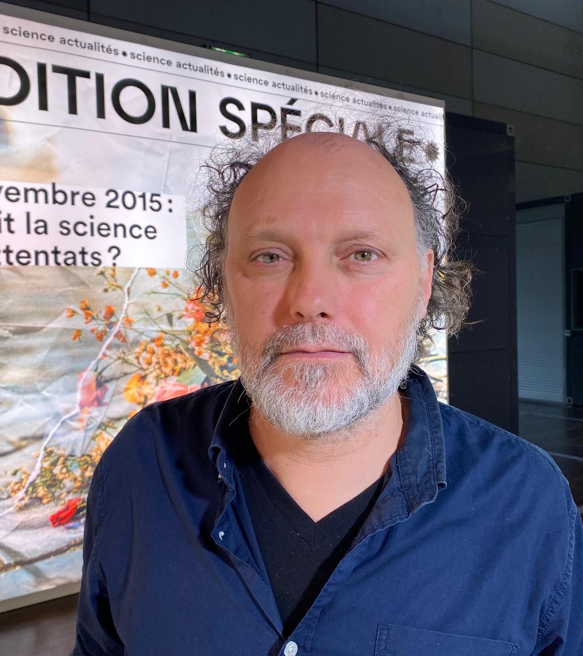 Portrait von einem weißen Mann mit Halbglatze in navy-blauem Hemd, der in die Kamera lächelt.