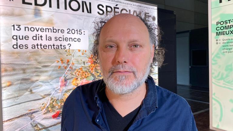 Portrait von einem weißen Mann mit Halbglatze in navy-blauem Hemd, der in die Kamera lächelt.