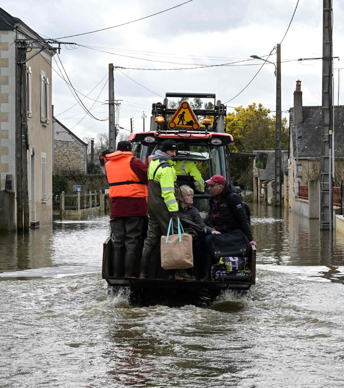 Bewohner werden aus ihren Häusern evakuiert, die Straße steht unter Wasser.