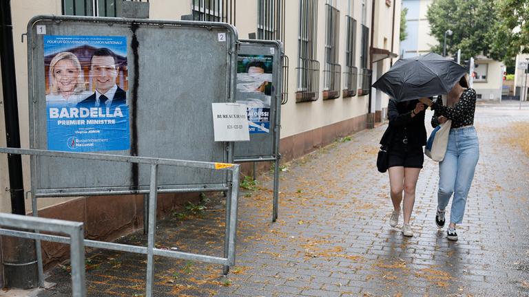 Wählerinnen gehen zur Stimmabgabe in der ersten Runde der außergewöhnlichen Parlamentswahlen in Frankreich