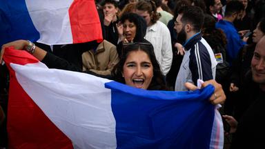 Eine Frau hält eine französische Nationalflagge bei einer Demonstration nachdem die ersten Ergebnisse der Parlamentswahlen veröffentlicht wurden. 