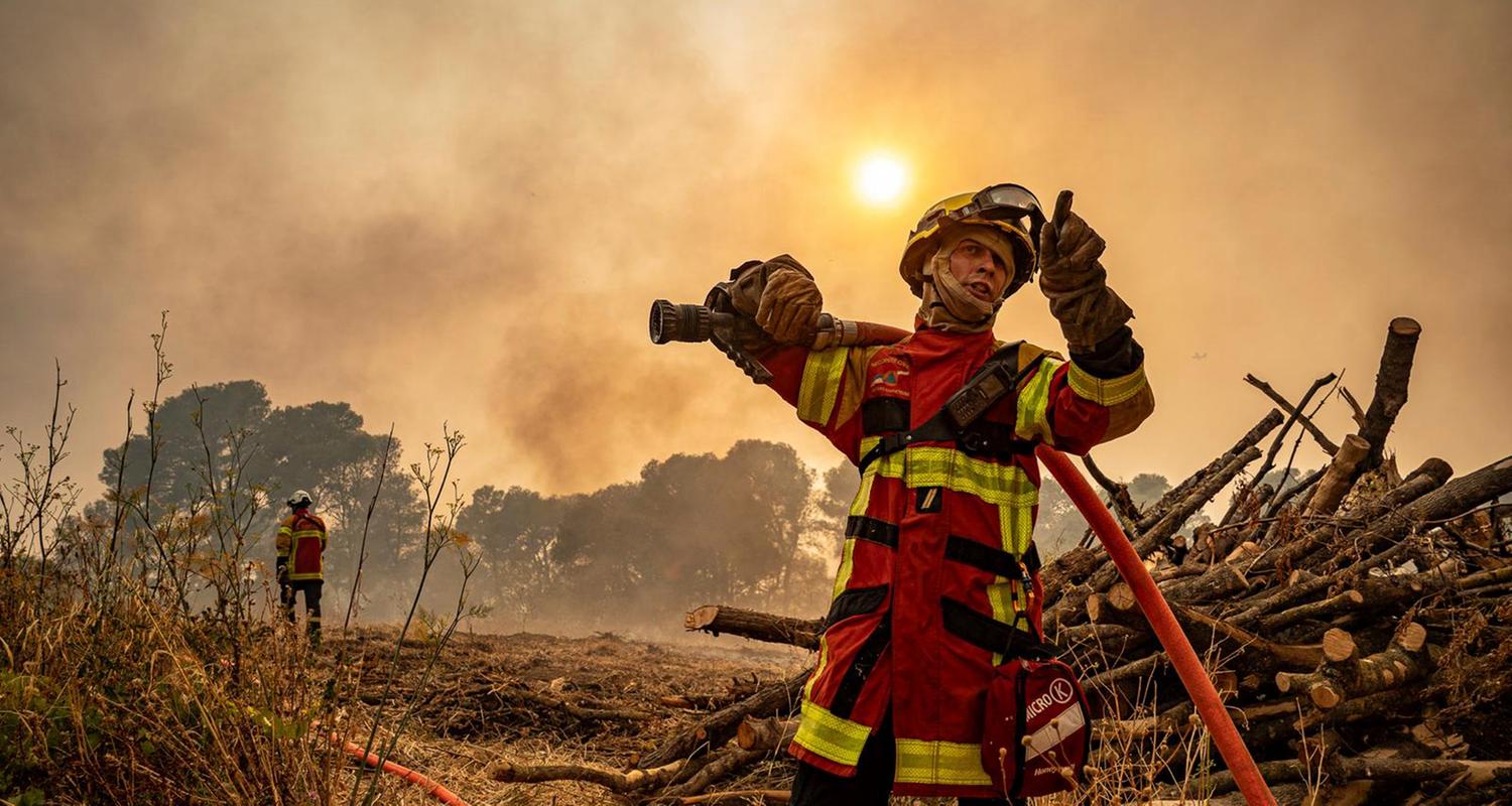 Ein Feuerwehrmann, der am Mittwoch, 6. August 2025, in der Nähe von Saint-Laurent-de-la-Cabrerisse, Südfrankreich, mit einem Schlauch gegen einen Waldbrand vorgeht.