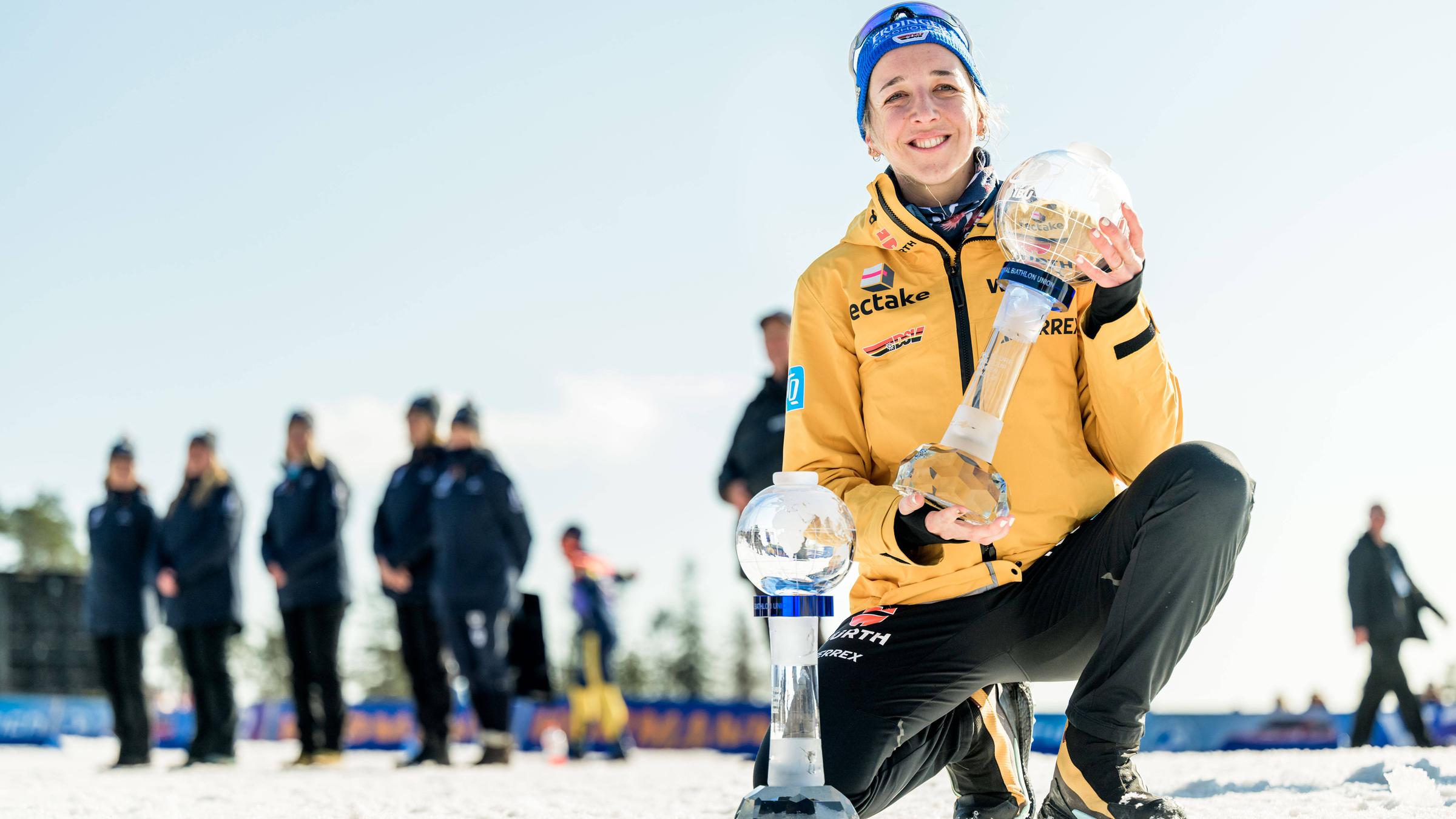 Franziska Preuß mit den Trophäen für den den Gewinn des Gesamt- und Massenstart-Weltcup