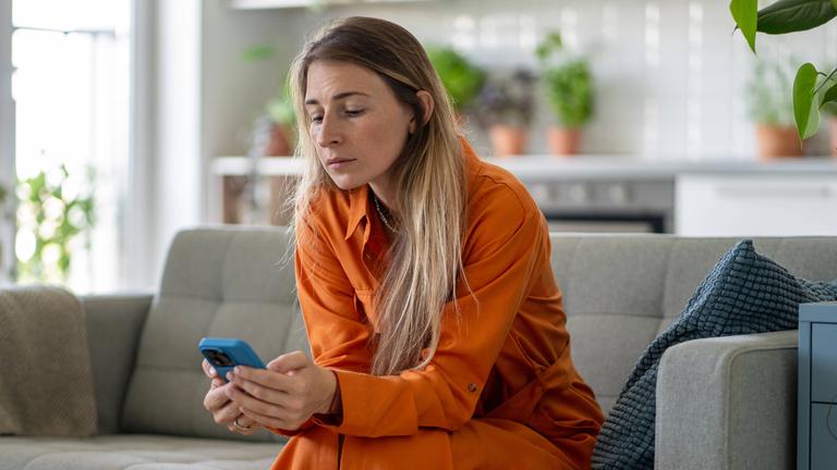 Eine Frau schaut auf den Bildschirm ihres Smartphones