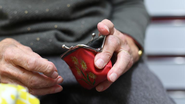 Baden-Württemberg, Weingarten: Eine Rentnerin hält in Weingarten ihren geöffneten Geldbeutel in ihrer Hand.