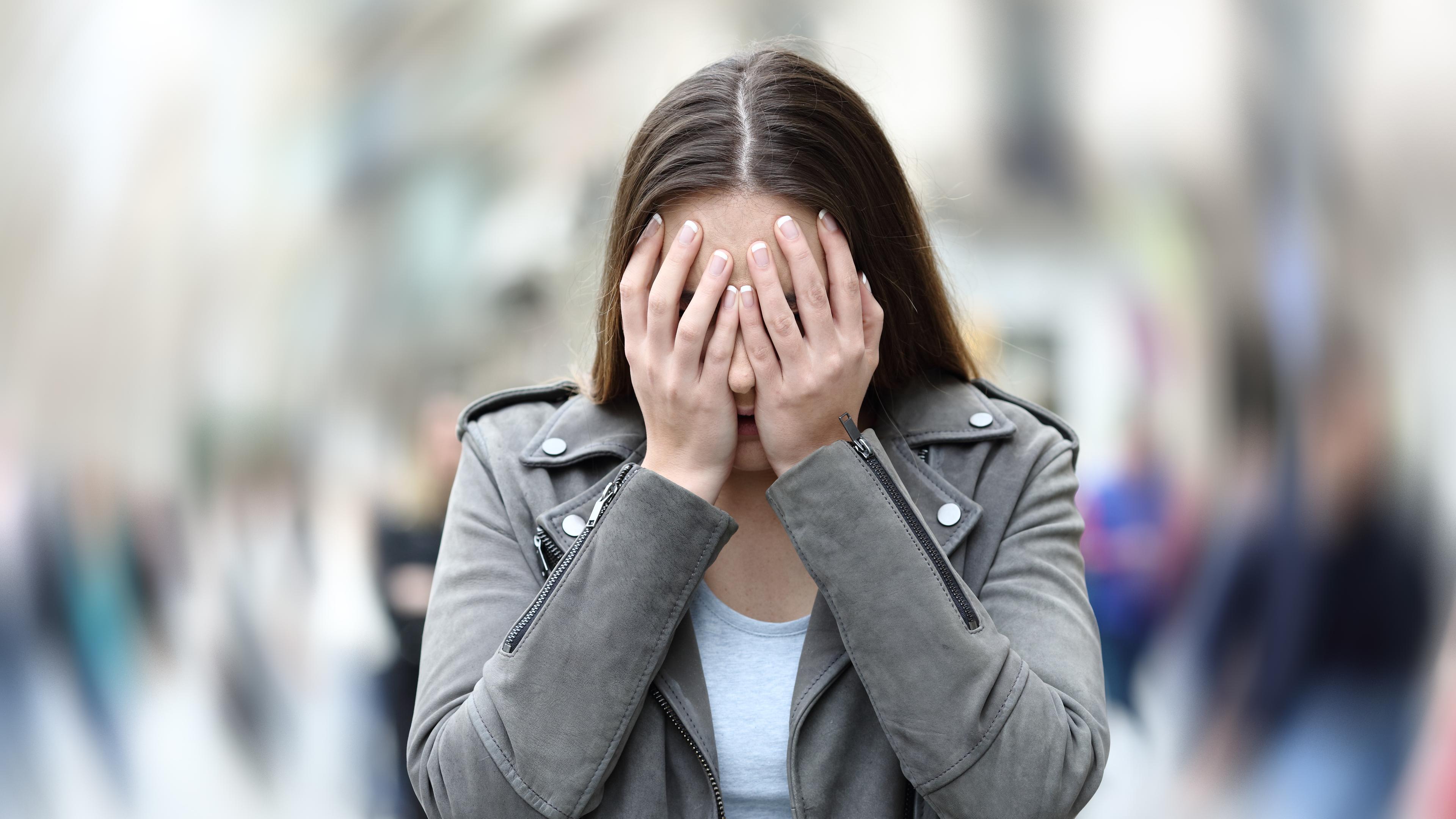 Frau hält sich die Hände vor das Gesicht