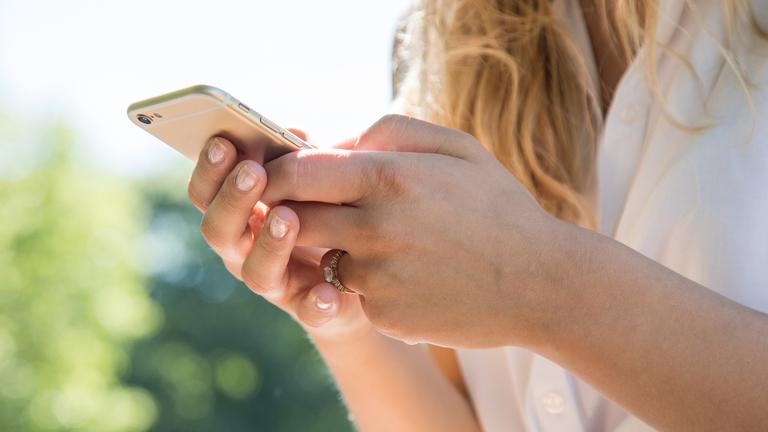 Es ist eine Frau am Smartphone zu sehen