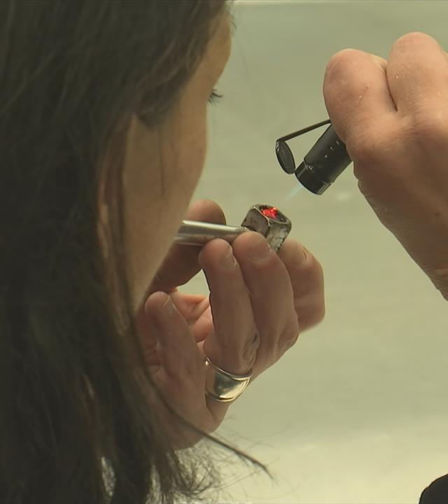 Frau zündet sich eine Crack Pfeife an.