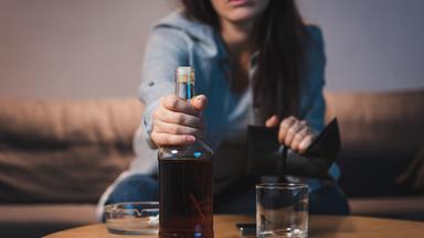 Frau trinkt Rum auf dem Sofa