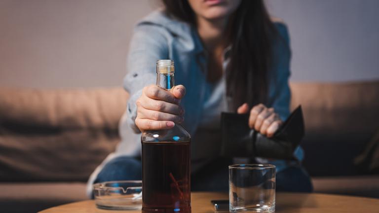 Frau trinkt Rum auf dem Sofa