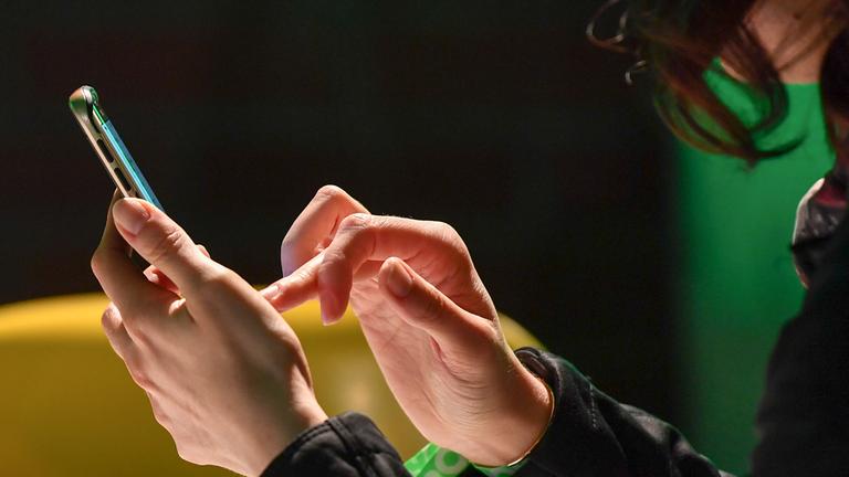 Frau tippt auf Smartphone