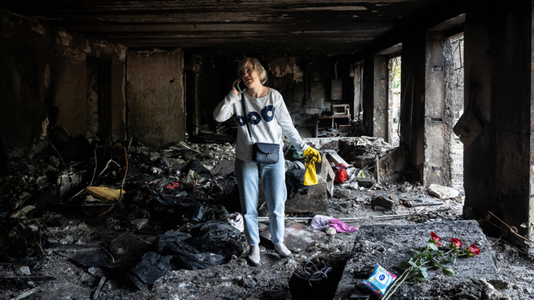 Frau in niedergebranntem Haus