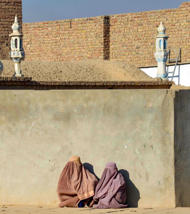 Verschleierte Frauen sitzen vor einer Moschee in Kandahar, Afghanistan.