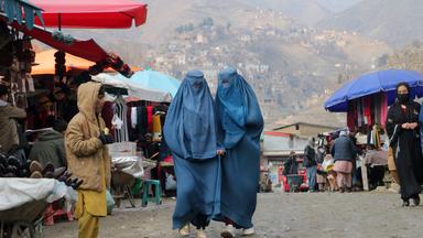 Zwei Frauen in Burka laufen durch einen Markt in Badakhshan, Afghanistan.