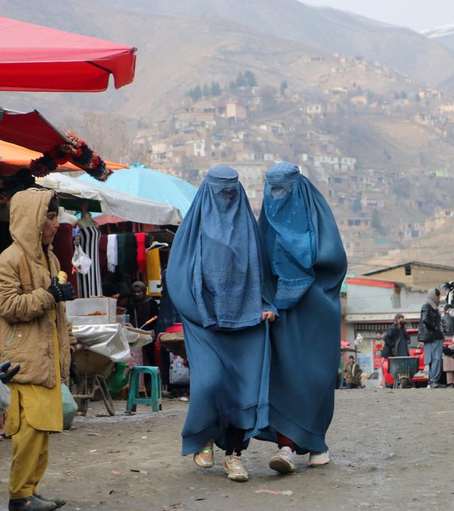 Zwei Frauen in Burka laufen durch einen Markt in Badakhshan, Afghanistan.