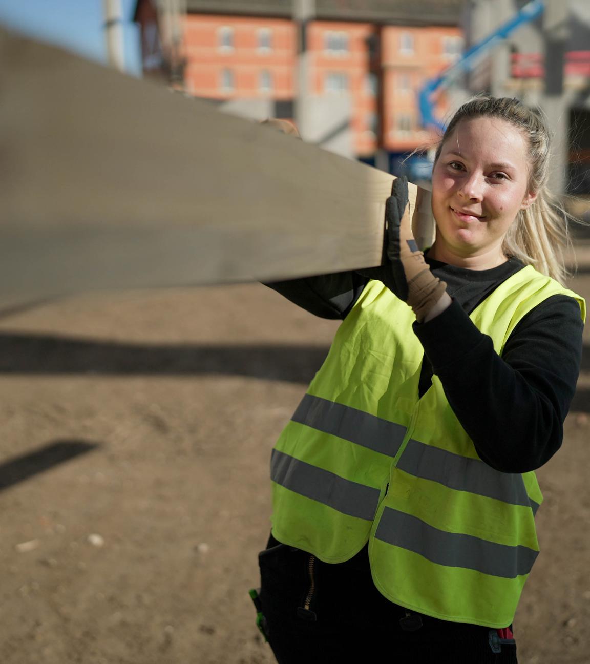 Hannah Scheurer trägt einen Dachbalken.