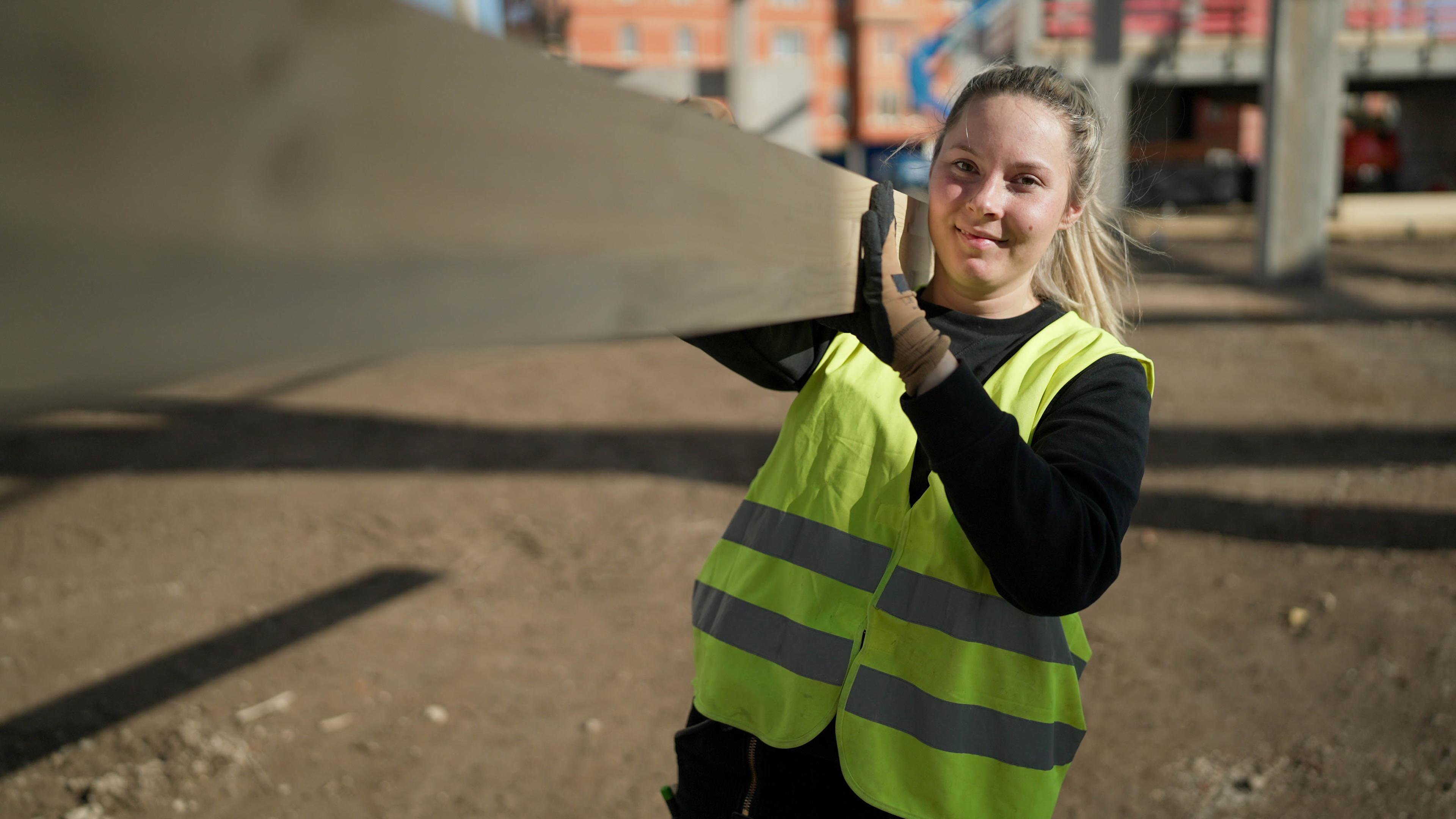Hannah Scheurer trägt einen Dachbalken.