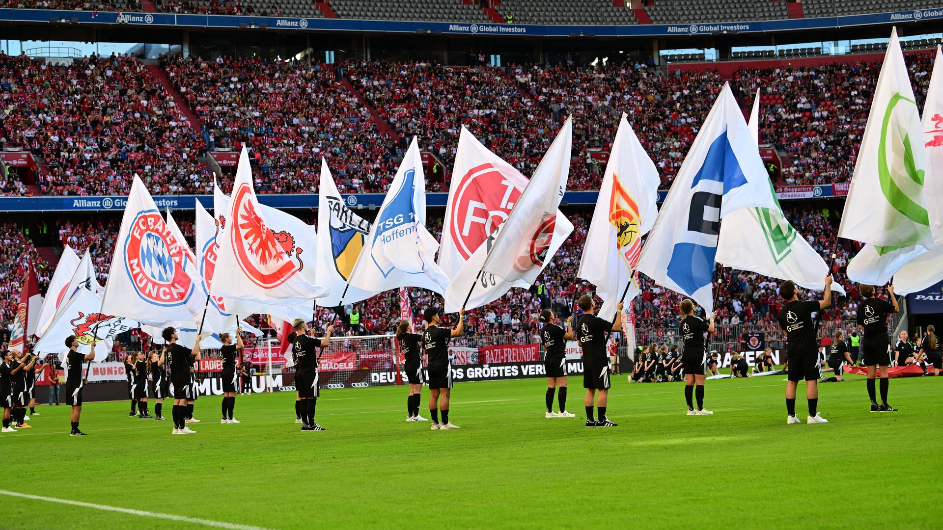 Die mit den Vereinswappen der Frauenbundesligaklubs bestückten Flaggen werden in der Allianz Arena in München geschwenkt