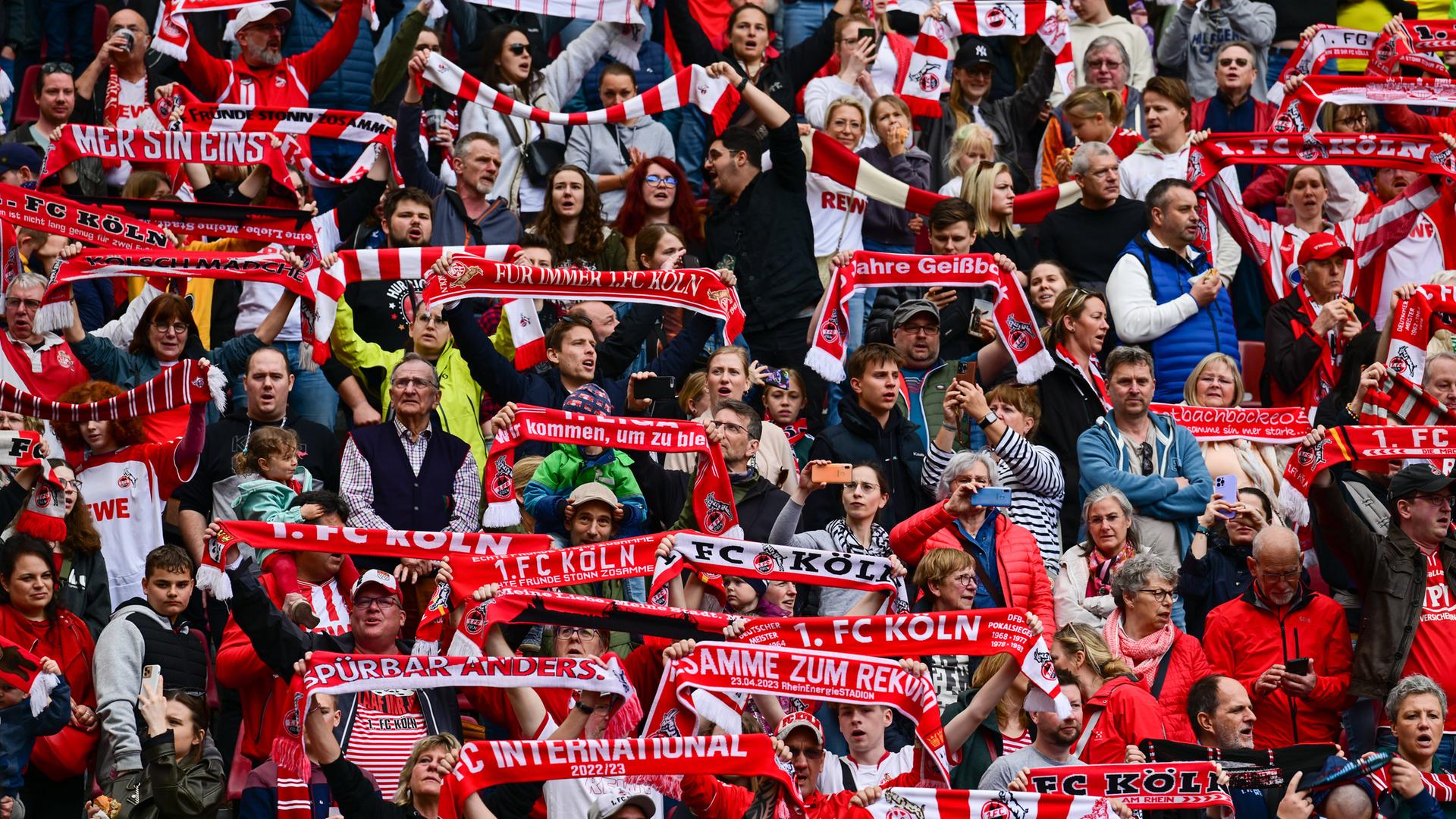 Fans halten während der Köln Hymne Schals nach oben. 
