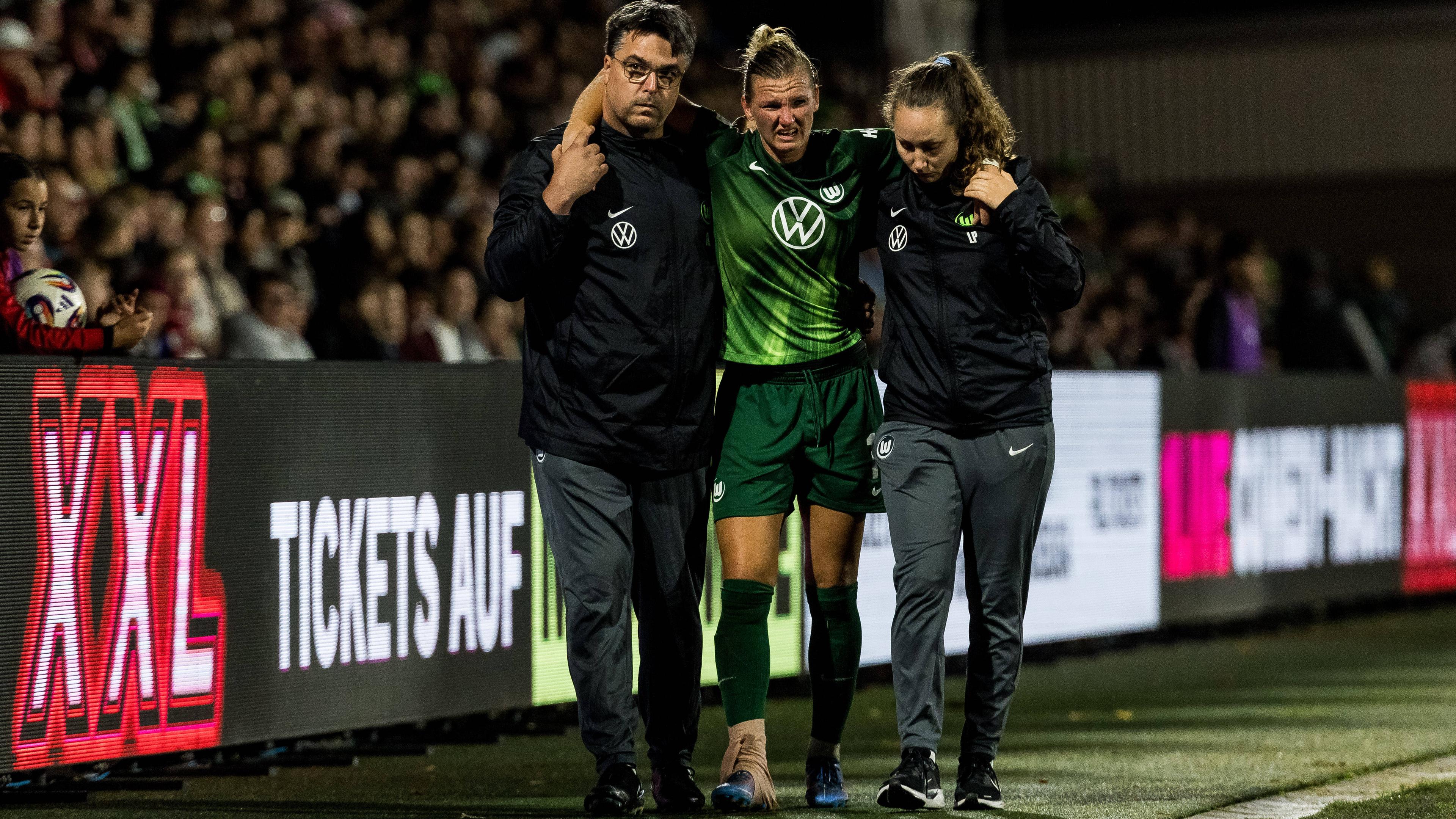 Alexandra Popp muss verletzt vom Platz begleitet werden.