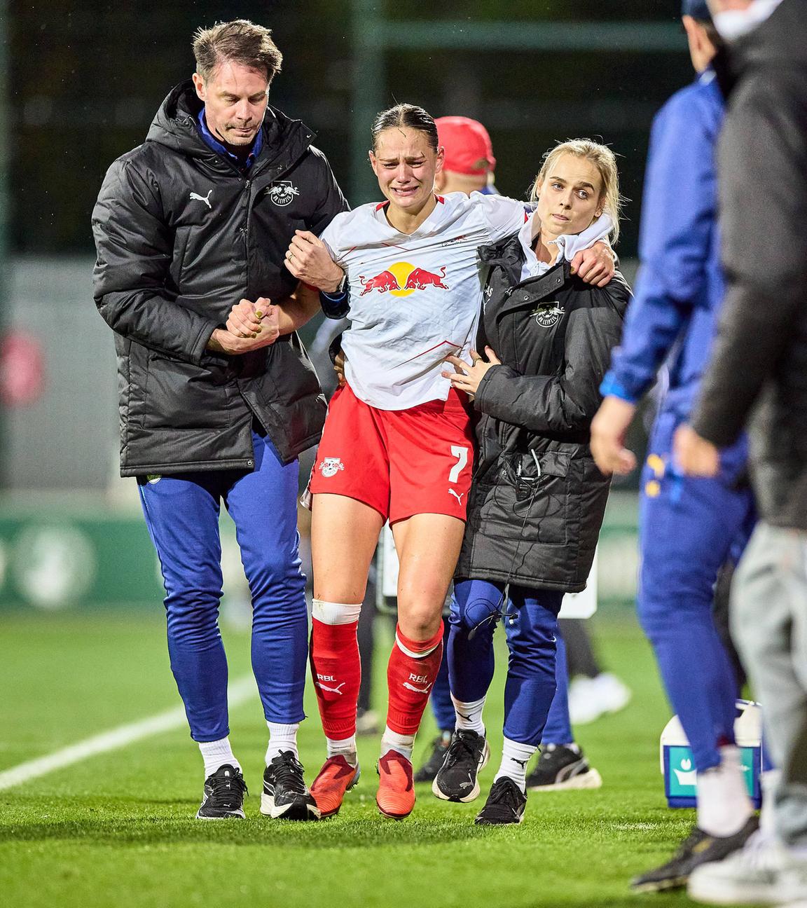 Leipzigs Giovanna Hoffmann verlässt verletzt den Platz und wird dabei unterstützt von Helfern.