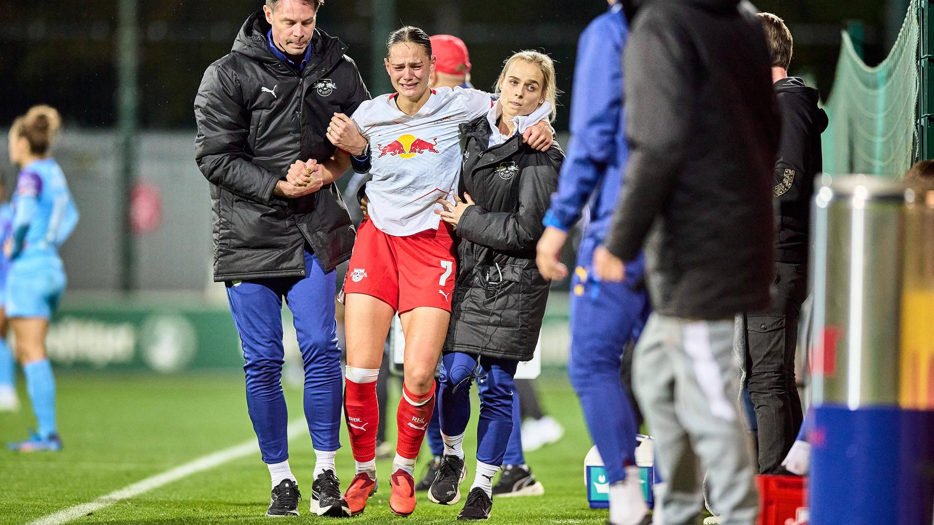 Leipzigs Giovanna Hoffmann verlässt verletzt den Platz und wird dabei unterstützt von Helfern.