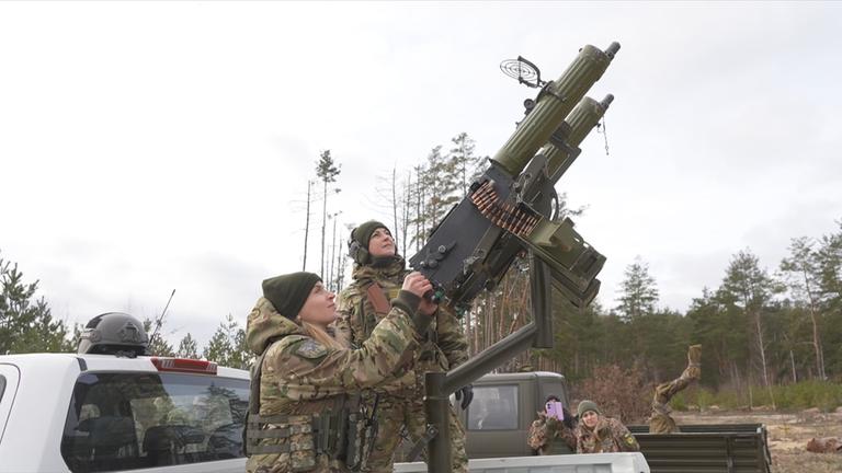 Zwei Frauen an einer Waffe