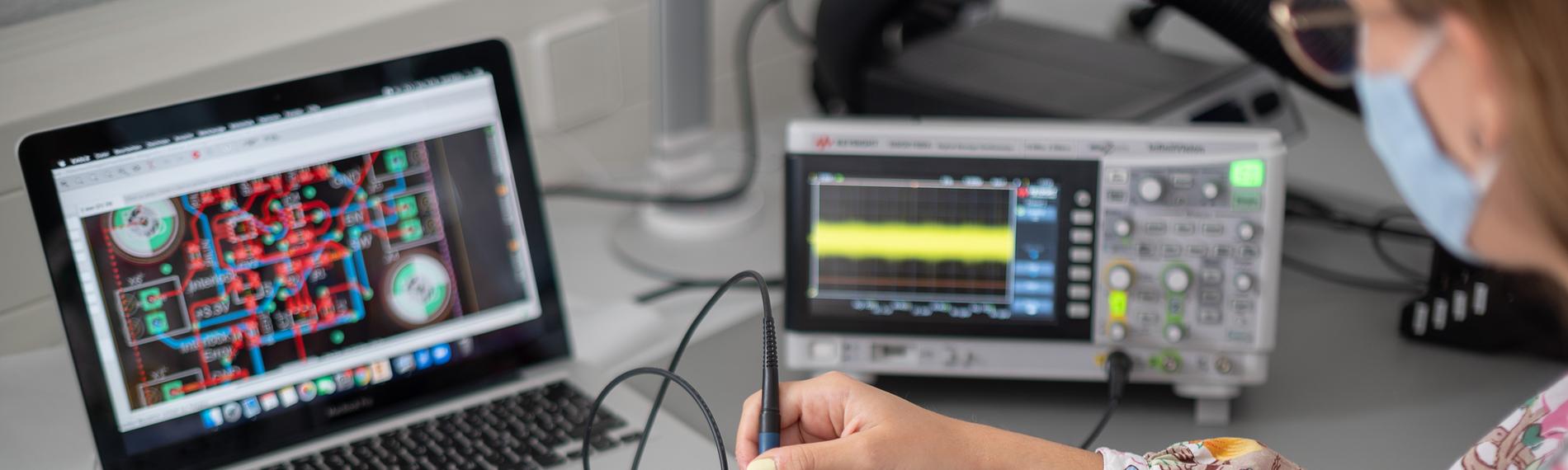 Eine Frau zeigt in einem Labor eines Technologieunternehmens eine Spannungsmessung an einem Quantensensor (gestellte Szene)