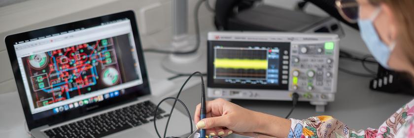 Eine Frau zeigt in einem Labor eines Technologieunternehmens eine Spannungsmessung an einem Quantensensor (gestellte Szene)