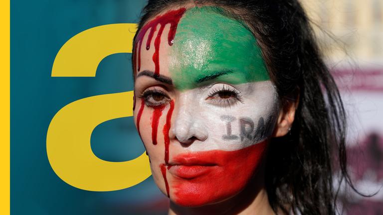Eine Teilnehmerin einer Solidaritätsdemonstration mit den Protestierenden im Iran hat sich das Gesicht mit den Farben der iranischen Flagge und mit rotem Blut geschminkt.