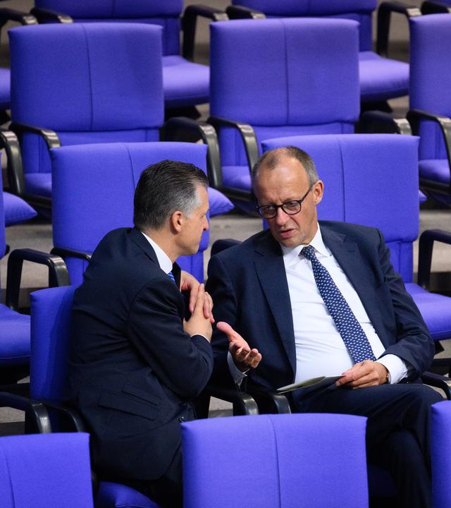 Thorsten Frei (l, CDU), Erster Parlamentarischer Geschäftsführer der CDU/CSU-Bundestagsfraktion, und Friedrich Merz, Vorsitzender der CDU/CSU-Bundestagsfraktion, unterhalten sich am Rande der Plenarsitzung im Deutschen Bundestag.