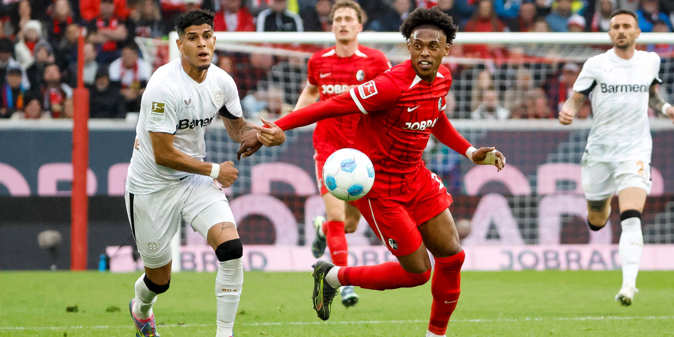 Leverkusens Piero Hincapie und Freiburgs Junior Adamu im Kampf um den Ball.