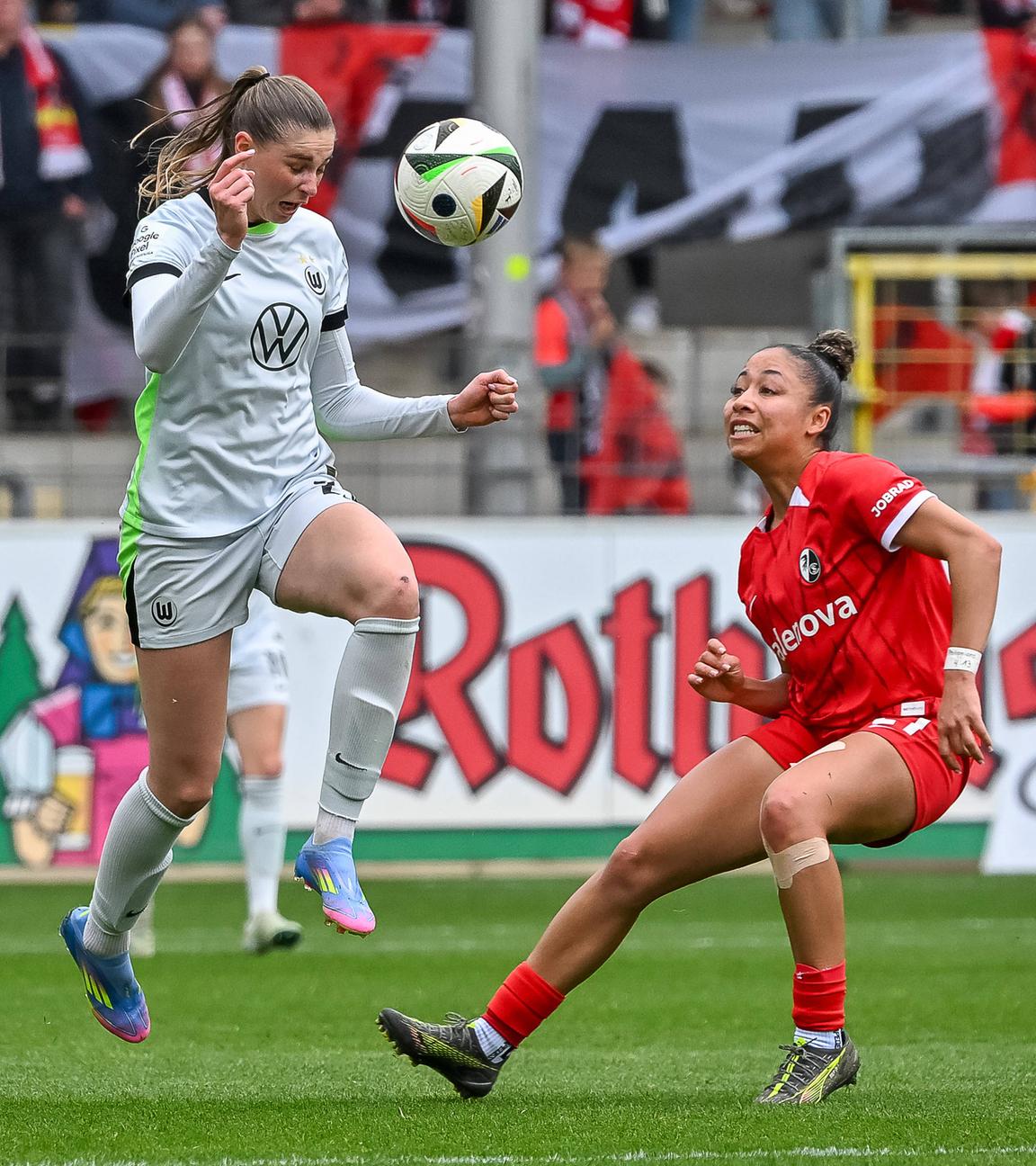 Wolfsburgs Jule Brand und Freiburgs Nicole Ojukwu im Kampf um den Ball beim Spiel am 13.04.2025.