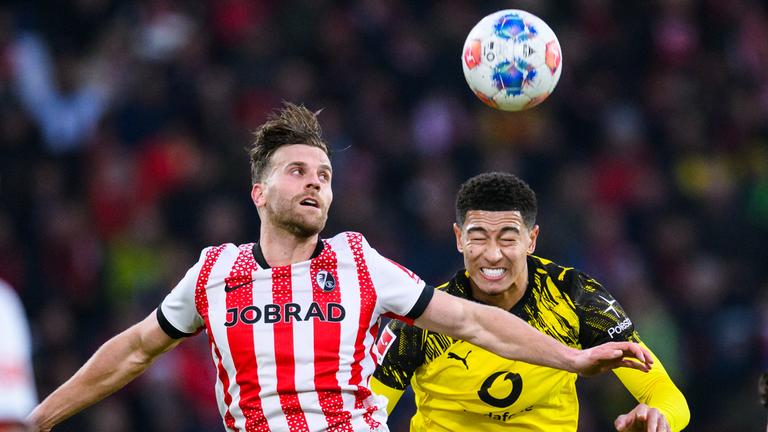 Lucas Höler (SC Freiburg) in Aktion gegen Jobe Bellingham (r, Borussia Dortmund)