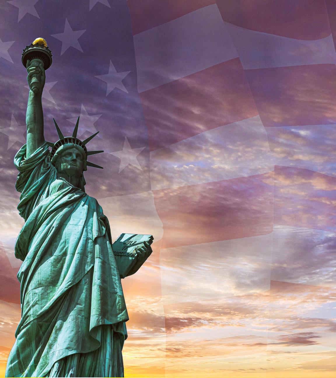 Die Freiheitsstatue - eine Frau mit Sternenkrone hält eine Fackel hoch - vor verschwommener US-Flagge