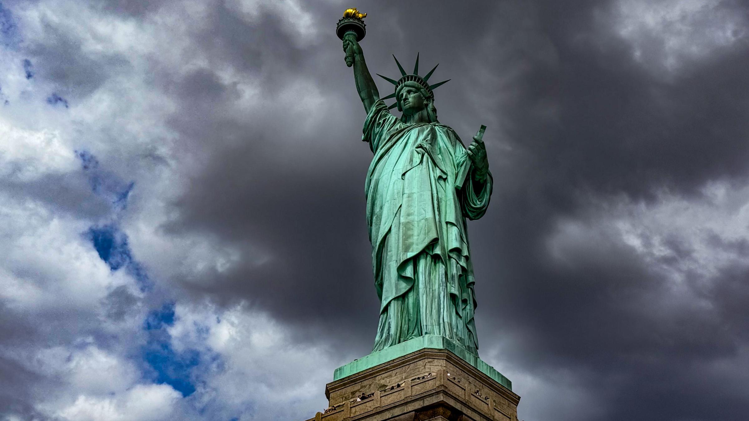 Freiheitsstatue vor dunklen Wolken