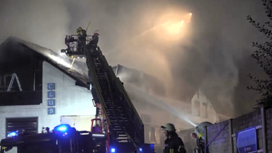 Das Bild zeigt einen Feuerwehreinsatz bei Nacht bei einem Clubhaus.