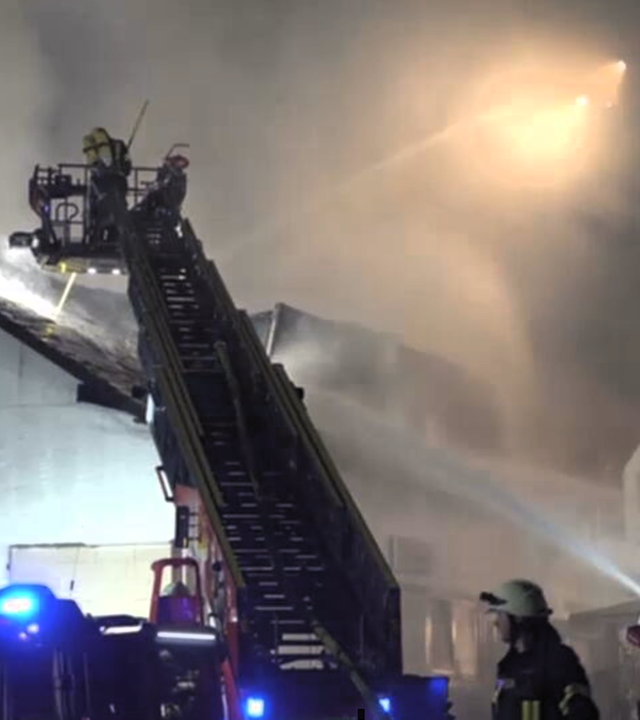 Das Bild zeigt einen Feuerwehreinsatz bei Nacht bei einem Clubhaus.