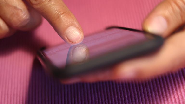 Bayern, Kaufbeuren: Eine Frau tippt auf einem iPhone. 