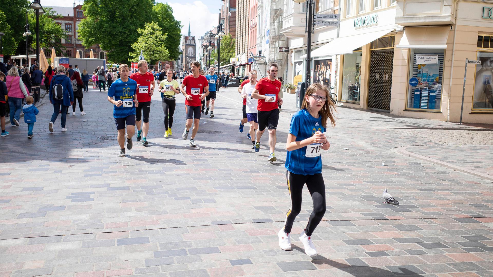 Freizeitsportler nehmen am Rostocker Citylauf teil und laufen durch die Innenstadt.