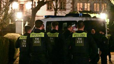 Thüringen, Fretterode: Einsatzkräfte der Polizei stehen vor einem Haus in Fretterode.