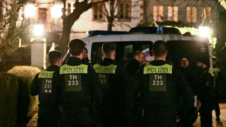 Thüringen, Fretterode: Einsatzkräfte der Polizei stehen vor einem Haus in Fretterode.